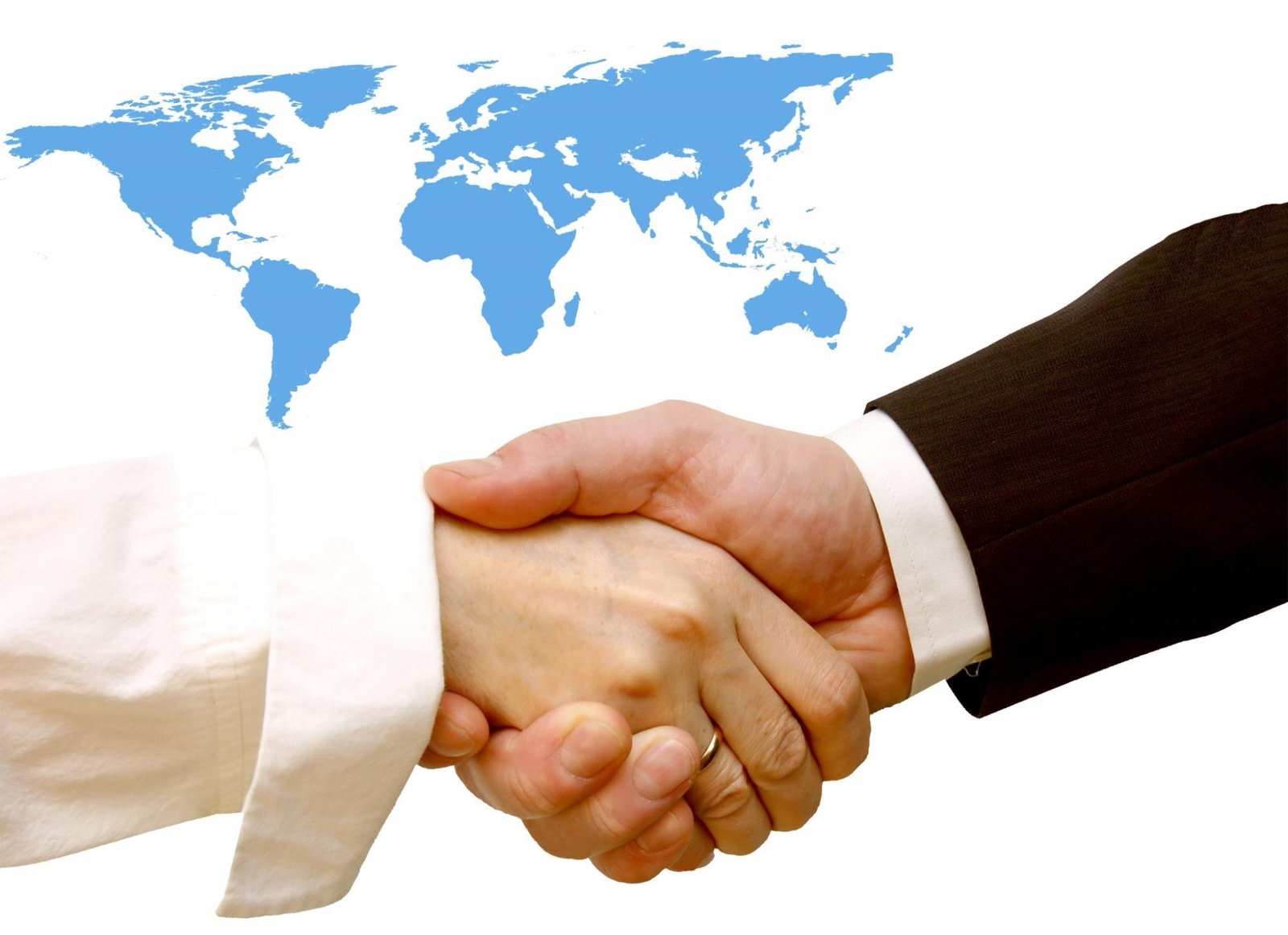 A close-up of a handshake between two people in business attire, one wearing a white shirt and the other a dark suit, set against a white background with a blue world map. The image symbolizes international business, global partnerships, or cross-border agreements.